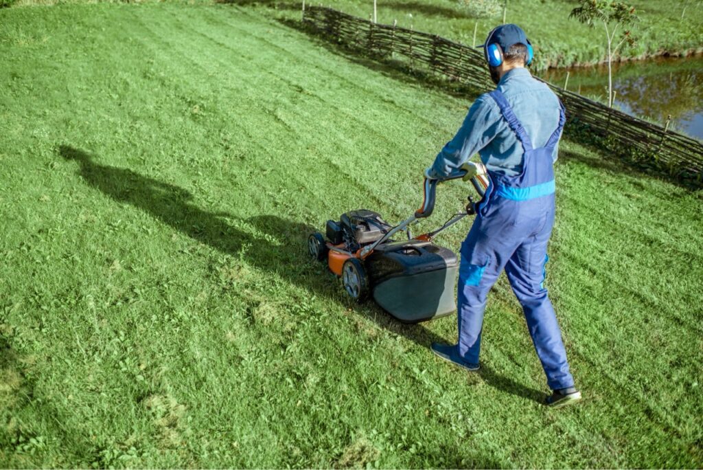Ein Mann mäht Rasen für den Hausmeisterservice in Porta Westfalica